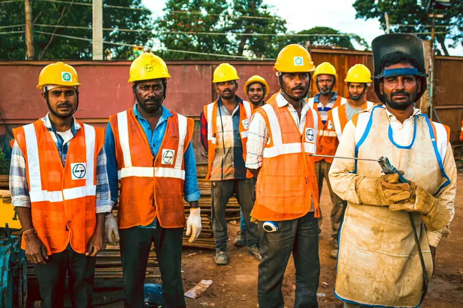 Group of workers wearing reflective hi-vis vests and hard hats