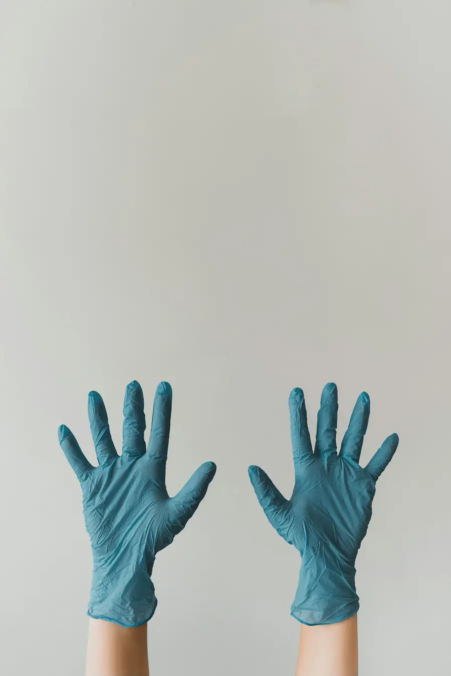 Hands wearing blue nitrile gloves
