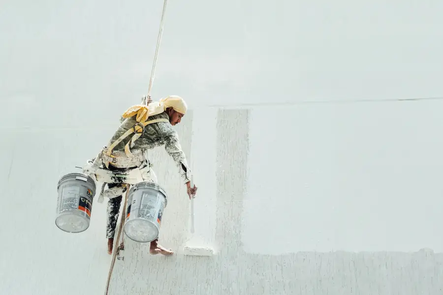 Painter painting a white interior wall