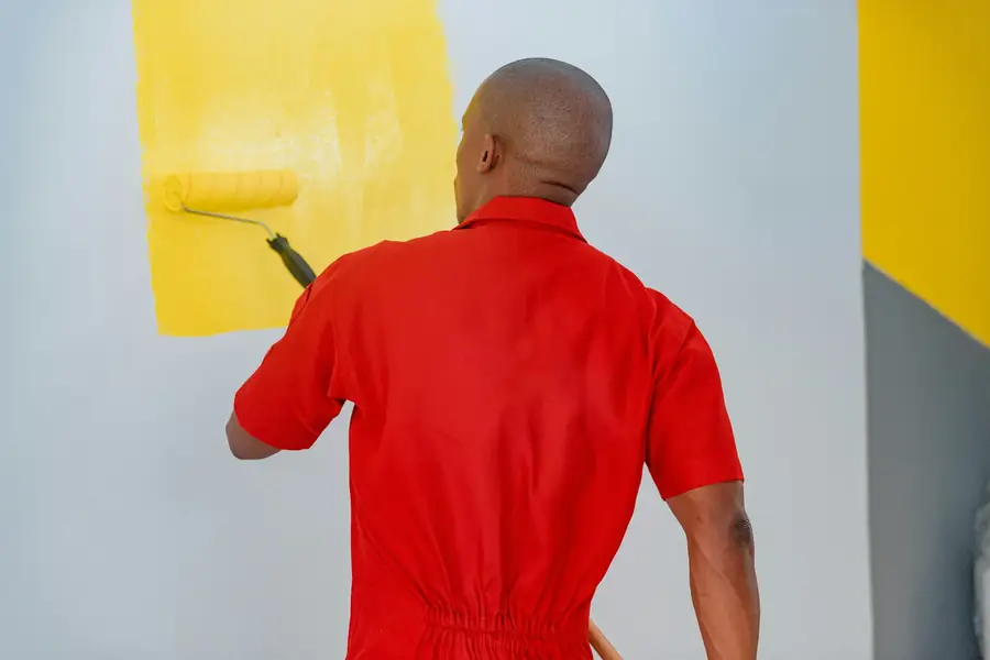 Painter applying paint to a wall with a roller