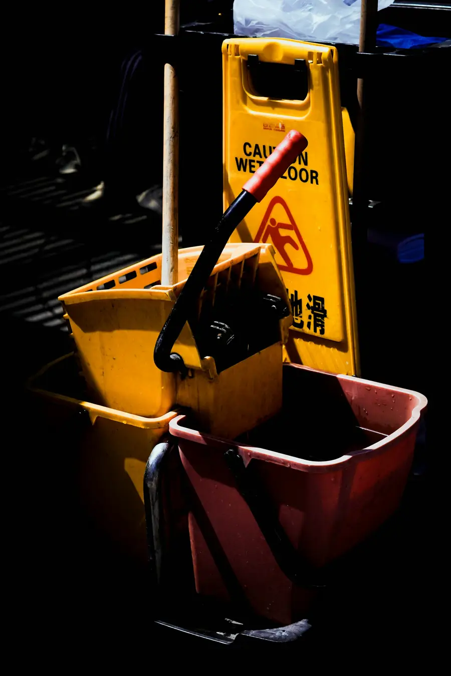 Yellow mop bucket, mop and caution wet floor sign